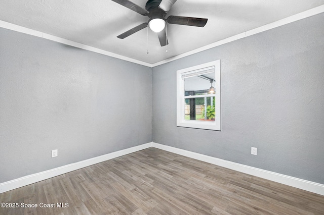 spare room with hardwood / wood-style floors, crown molding, and ceiling fan