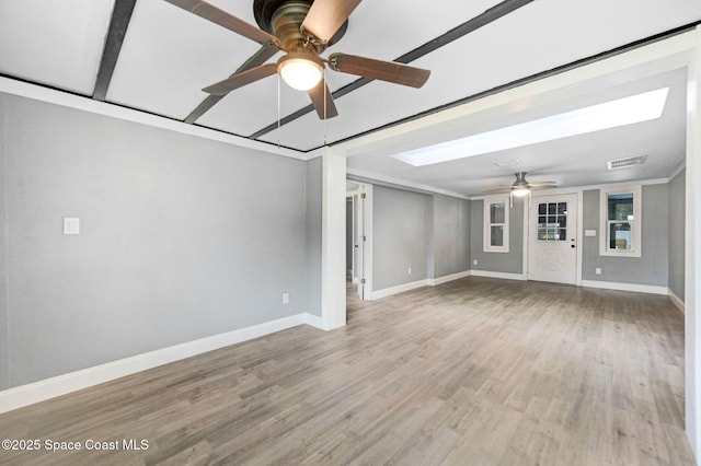 unfurnished living room with hardwood / wood-style floors, a skylight, and ceiling fan