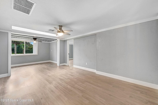 empty room with ceiling fan and light hardwood / wood-style flooring