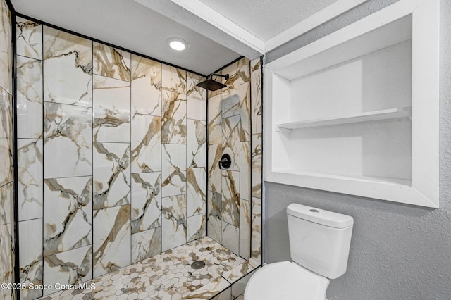 bathroom with tiled shower and toilet