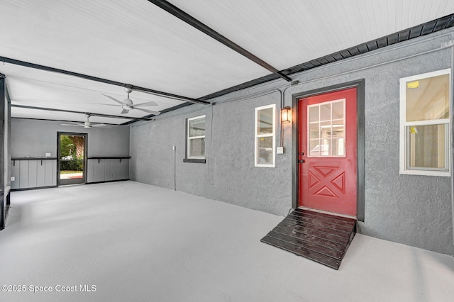 view of exterior entry with ceiling fan and a patio area