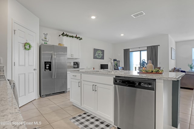 kitchen featuring stainless steel appliances, white cabinetry, light stone countertops, and light tile patterned floors