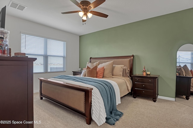 bedroom featuring multiple windows, light colored carpet, and ceiling fan