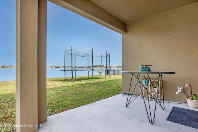 view of patio featuring a trampoline and a water view