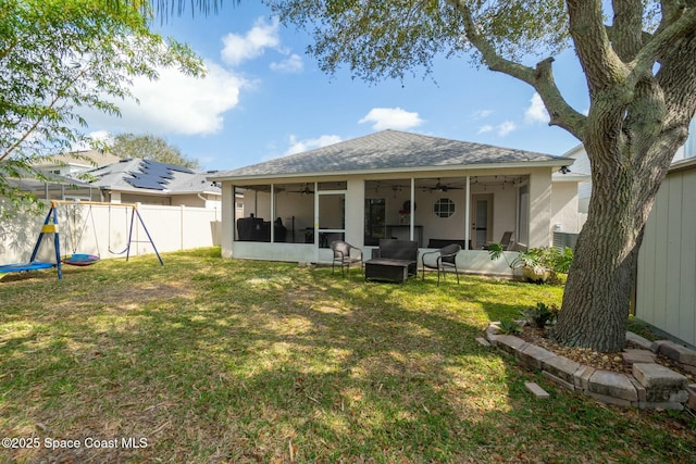 rear view of property with a yard, a sunroom, and ceiling fan