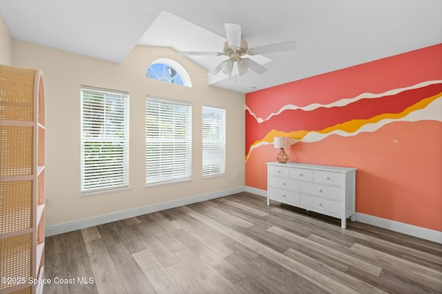 unfurnished bedroom featuring ceiling fan, lofted ceiling, and light hardwood / wood-style floors