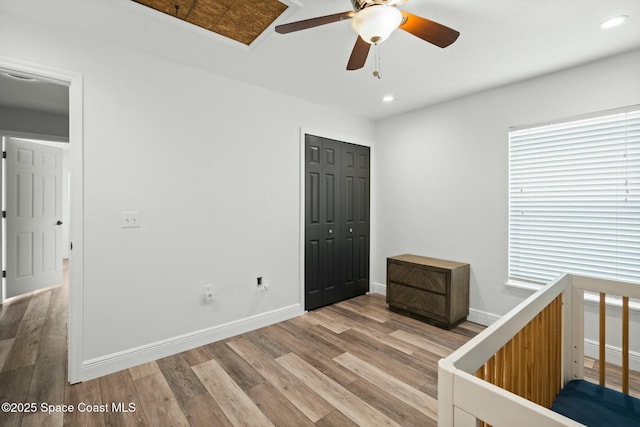 unfurnished bedroom with ceiling fan, light wood-type flooring, and a closet