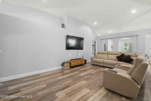 living room featuring lofted ceiling and light wood-type flooring