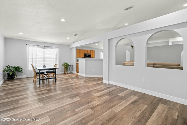 dining space featuring a textured ceiling and light wood-type flooring