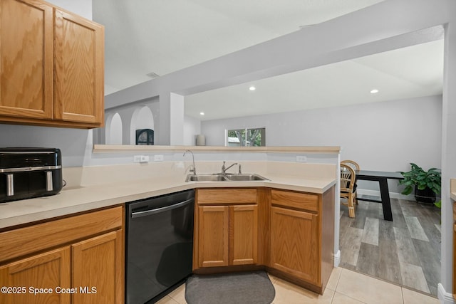 kitchen with dishwasher, sink, kitchen peninsula, and light tile patterned floors