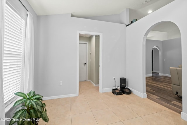 tiled spare room with vaulted ceiling