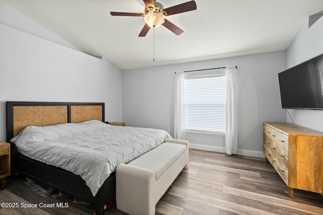 bedroom featuring hardwood / wood-style flooring, vaulted ceiling, and ceiling fan