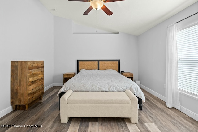 bedroom with lofted ceiling, wood-type flooring, and multiple windows