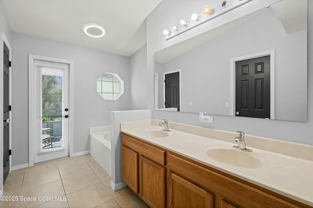 bathroom with tile patterned floors, a bath, and vanity