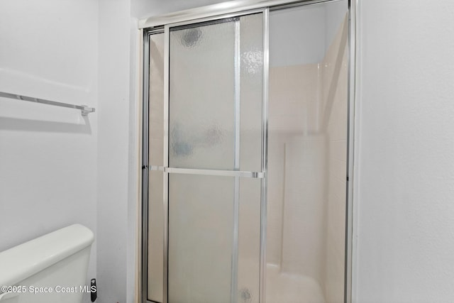 bathroom featuring an enclosed shower and toilet