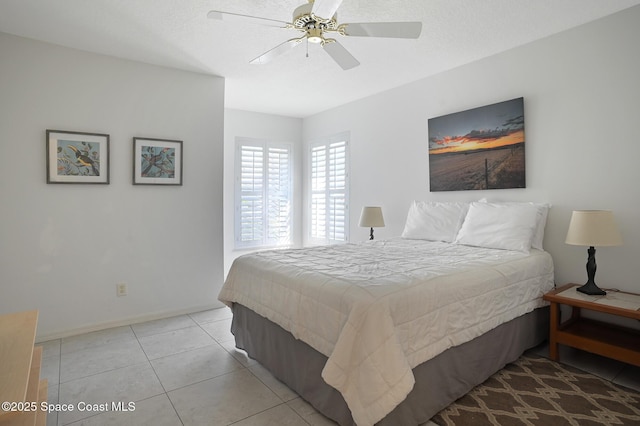 tiled bedroom featuring ceiling fan and a textured ceiling