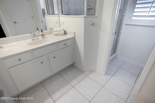 bathroom featuring tile patterned flooring, vanity, and a shower with shower door