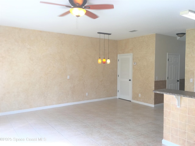 tiled spare room featuring ceiling fan