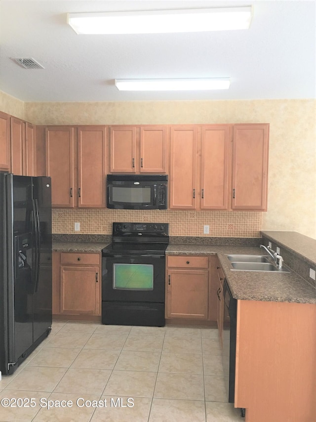 kitchen with tasteful backsplash, light tile patterned floors, sink, and black appliances