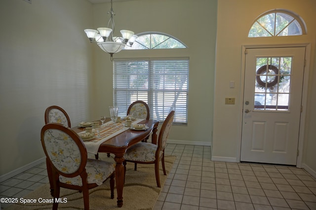 dining space with light tile patterned floors, a notable chandelier, and baseboards