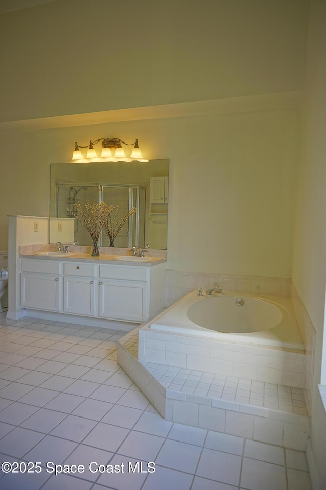 full bathroom featuring double vanity, a stall shower, a bath, and a sink