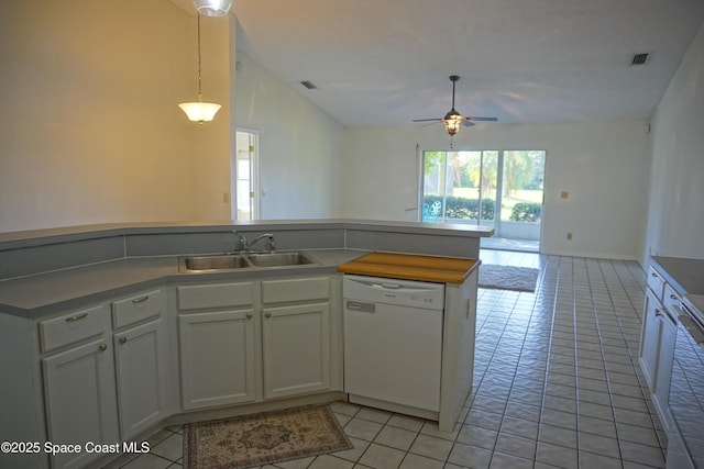 kitchen with visible vents, light tile patterned flooring, white dishwasher, a sink, and vaulted ceiling