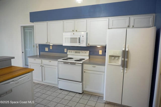 kitchen featuring white appliances, light tile patterned flooring, light countertops, and white cabinetry