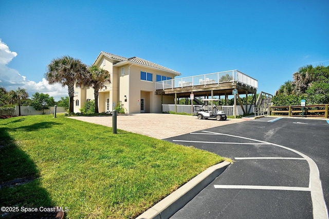 view of car parking with basketball court and a lawn