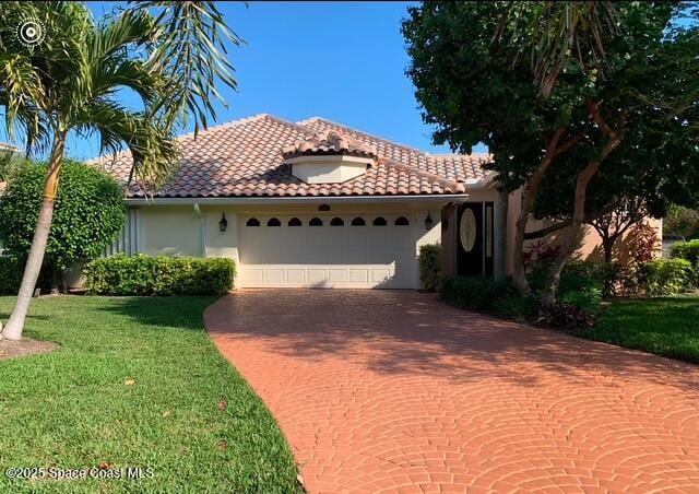 mediterranean / spanish house featuring a garage and a front yard