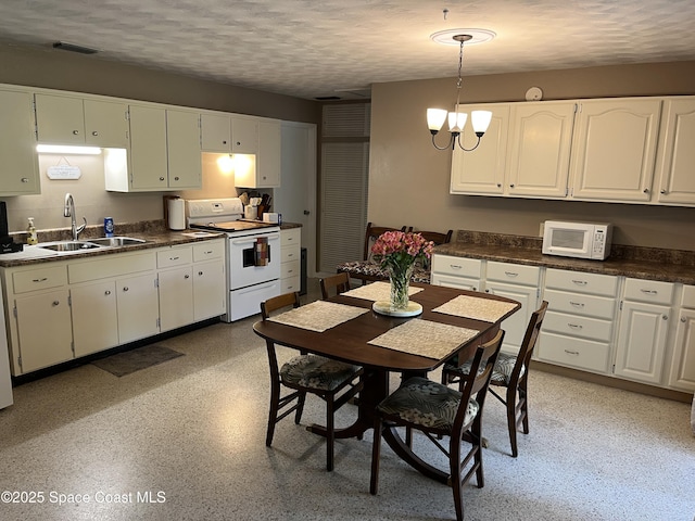 kitchen featuring sink, white cabinetry, a chandelier, a textured ceiling, and white appliances