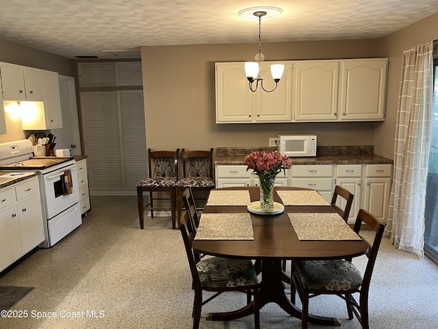 dining room featuring a textured ceiling and a notable chandelier