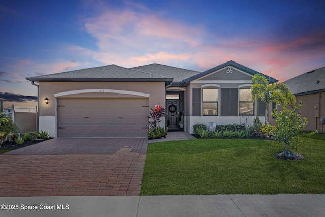 ranch-style home with a yard and a garage