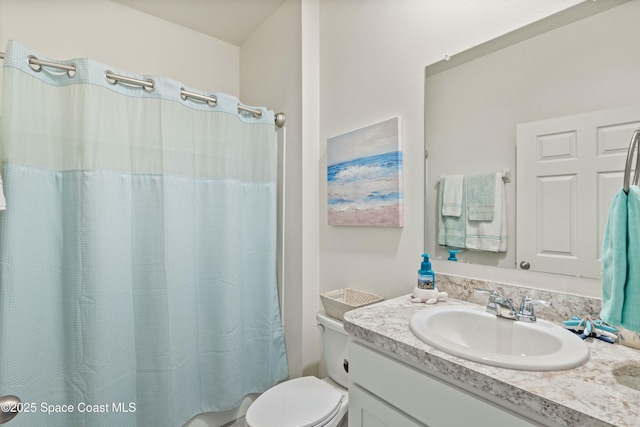 bathroom with vanity, walk in shower, and toilet