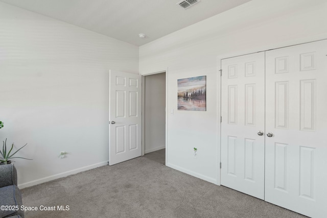 unfurnished bedroom featuring light carpet and a closet