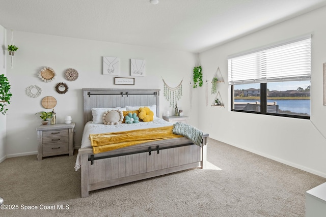 bedroom with a water view and carpet flooring