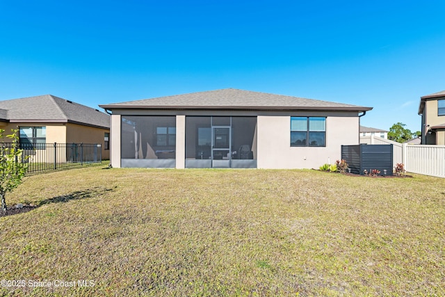 rear view of property featuring a sunroom and a yard