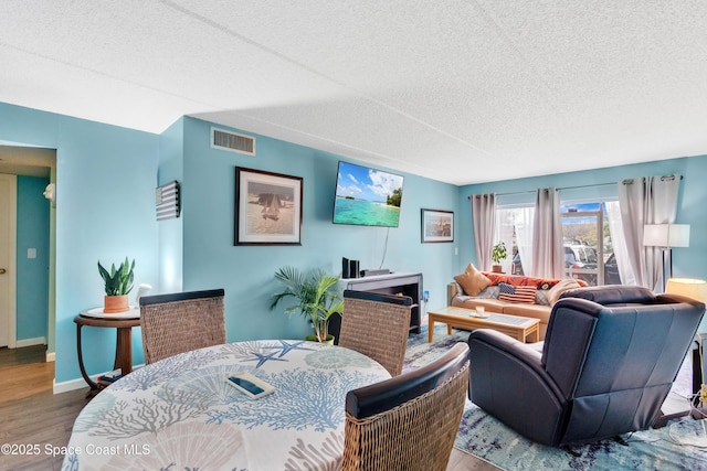 dining area with hardwood / wood-style floors and a textured ceiling