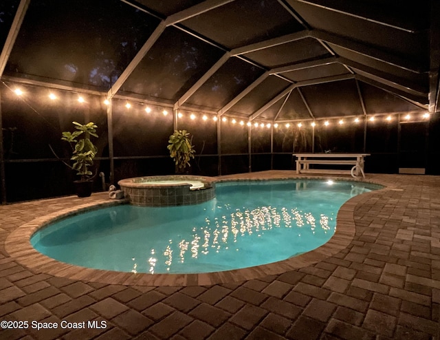 view of pool featuring an in ground hot tub, glass enclosure, and a patio area