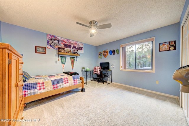 bedroom with ceiling fan, carpet, and a textured ceiling