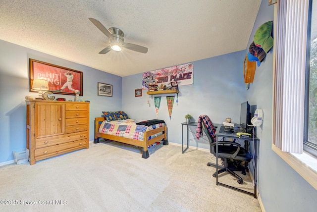 carpeted bedroom with ceiling fan and a textured ceiling