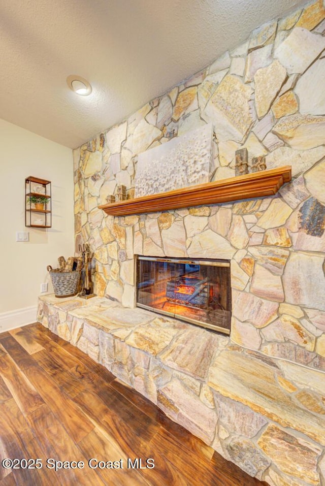 room details with hardwood / wood-style flooring, a fireplace, and a textured ceiling