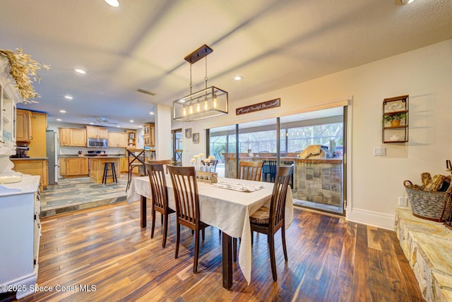 dining room featuring dark wood-type flooring and a textured ceiling