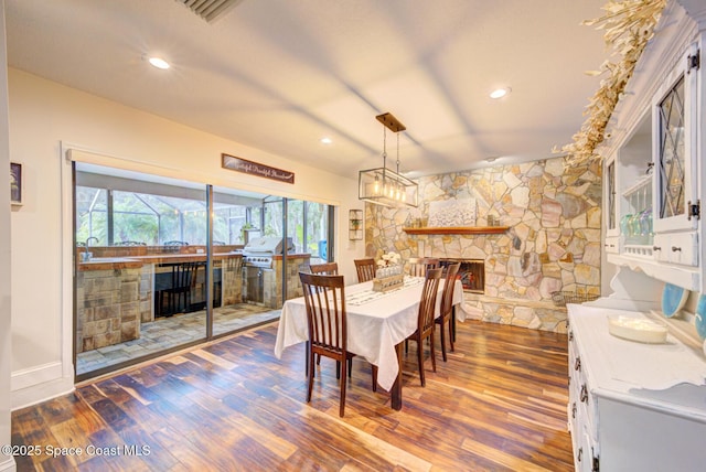 dining space featuring dark wood-type flooring and a fireplace