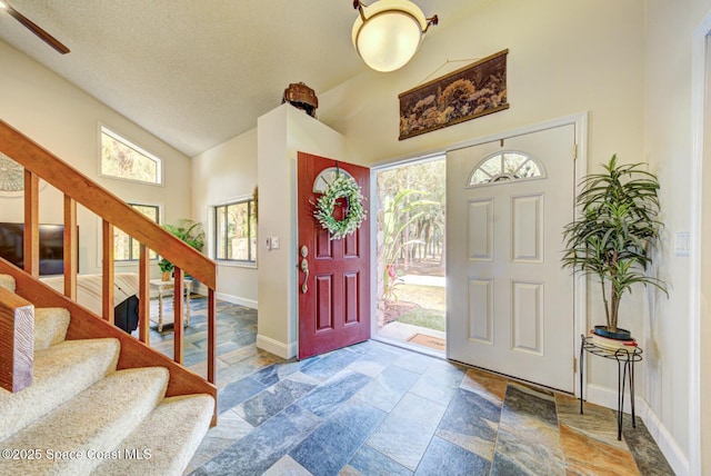 entrance foyer with high vaulted ceiling and a textured ceiling