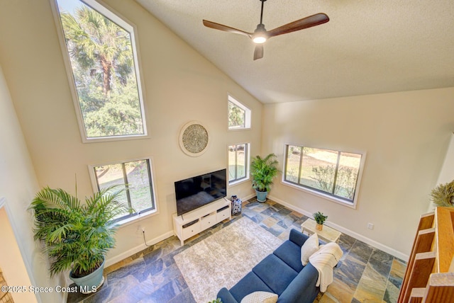 living room featuring ceiling fan, high vaulted ceiling, and a textured ceiling