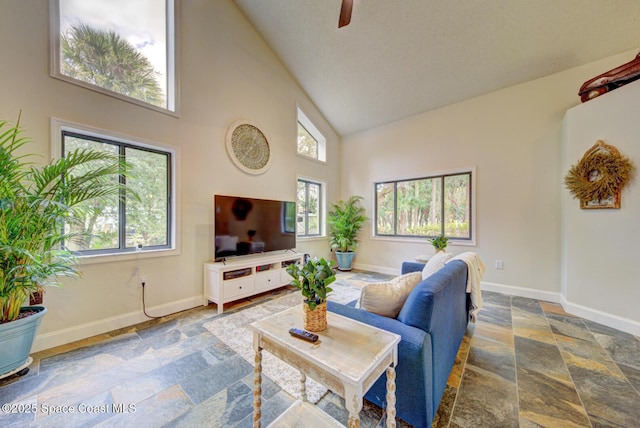 living room featuring ceiling fan, plenty of natural light, and high vaulted ceiling