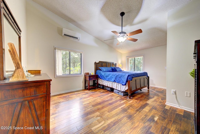 bedroom featuring lofted ceiling, a textured ceiling, a wall unit AC, hardwood / wood-style flooring, and ceiling fan