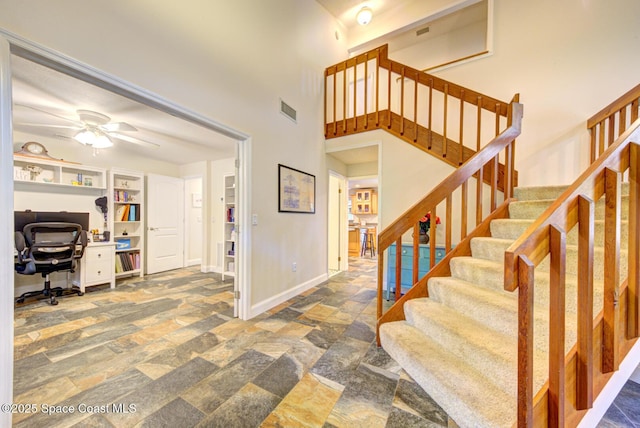 entryway featuring a towering ceiling and ceiling fan