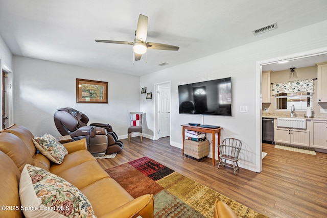 living room featuring sink, hardwood / wood-style flooring, and ceiling fan