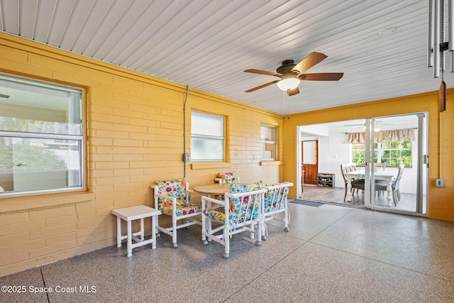 sunroom / solarium featuring ceiling fan